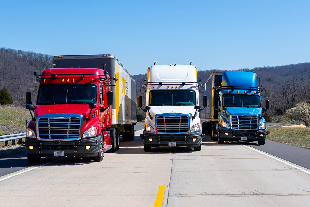 Three semi-trucks parked on a road