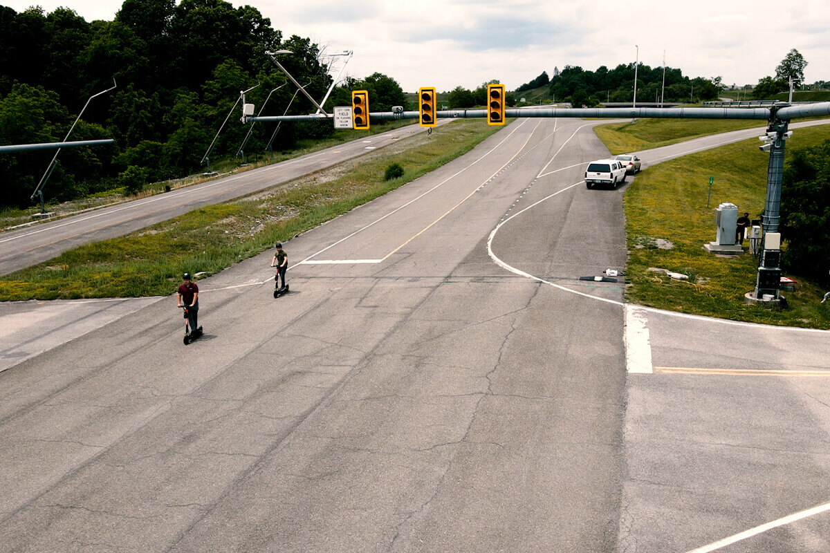 Two people on a scooter riding through the intersection on the Virginia Smart Roads